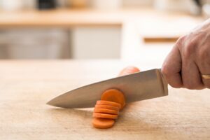 Couteau de chef en train de trancher une carotte